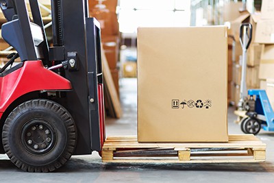 A forklift moving a box on a pallet